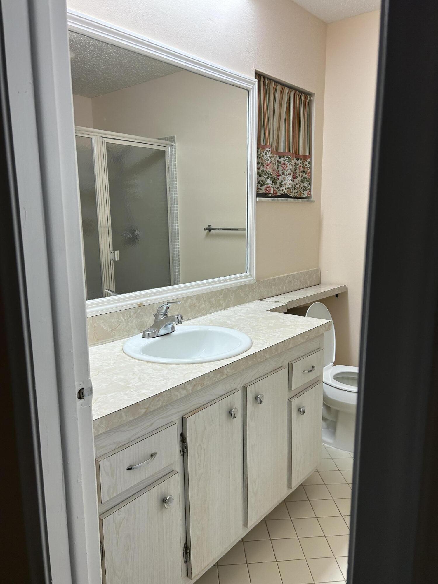 2003 Southwest 18th Street Boynton Beach, FL 33426 - Photo 7 of 11 a bathroom with a double vanity sink and a mirror