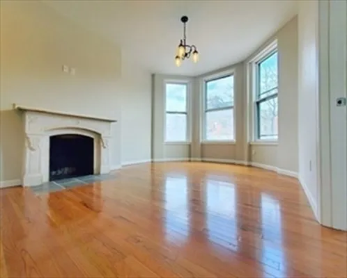 a view of an empty room with a fireplace and a window