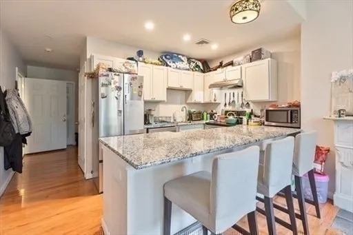 a kitchen with stainless steel appliances granite countertop a sink refrigerator and cabinets