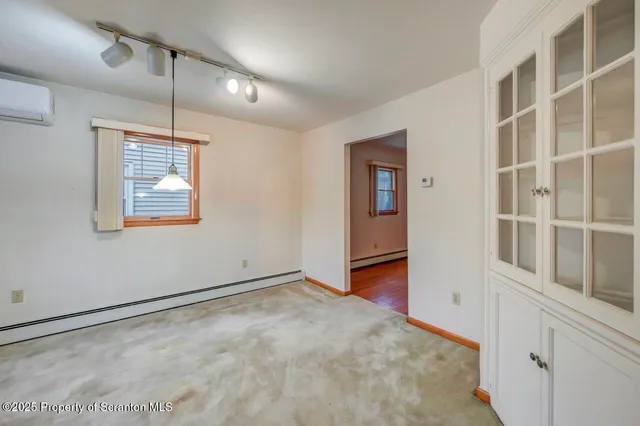 a large white kitchen with a sink a window and stainless steel appliances