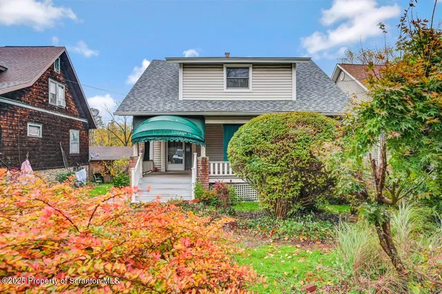 a front view of house with yard and trees in the background