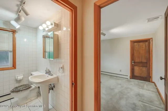 a view of a white house with large outdoor space and a street