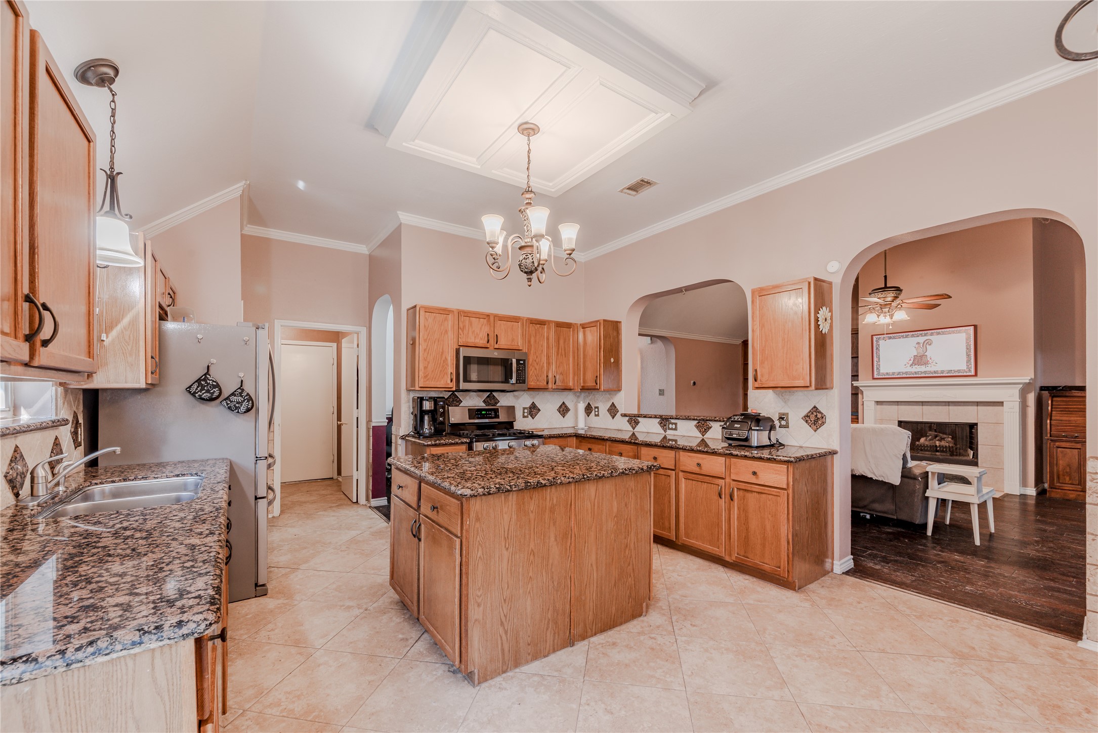 7714 Broken Arrow Street Baytown, TX 77521 - Photo 12 of 41 a kitchen with stainless steel appliances granite countertop a stove top oven a sink a dining table and chairs with wooden floor