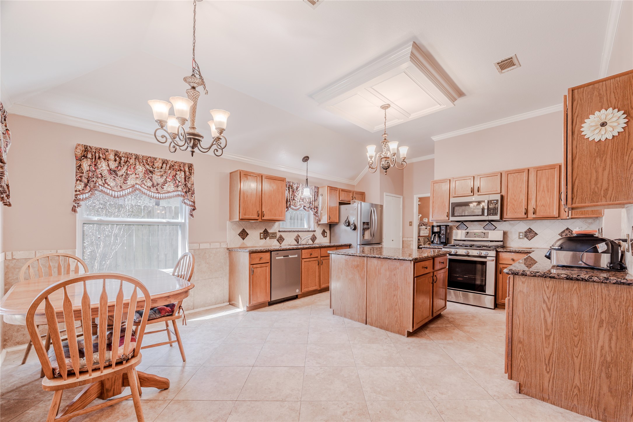 7714 Broken Arrow Street Baytown, TX 77521 - Photo 16 of 41 a open kitchen with stainless steel appliances granite countertop a stove top oven a sink dishwasher a dining table and chairs with wooden floor