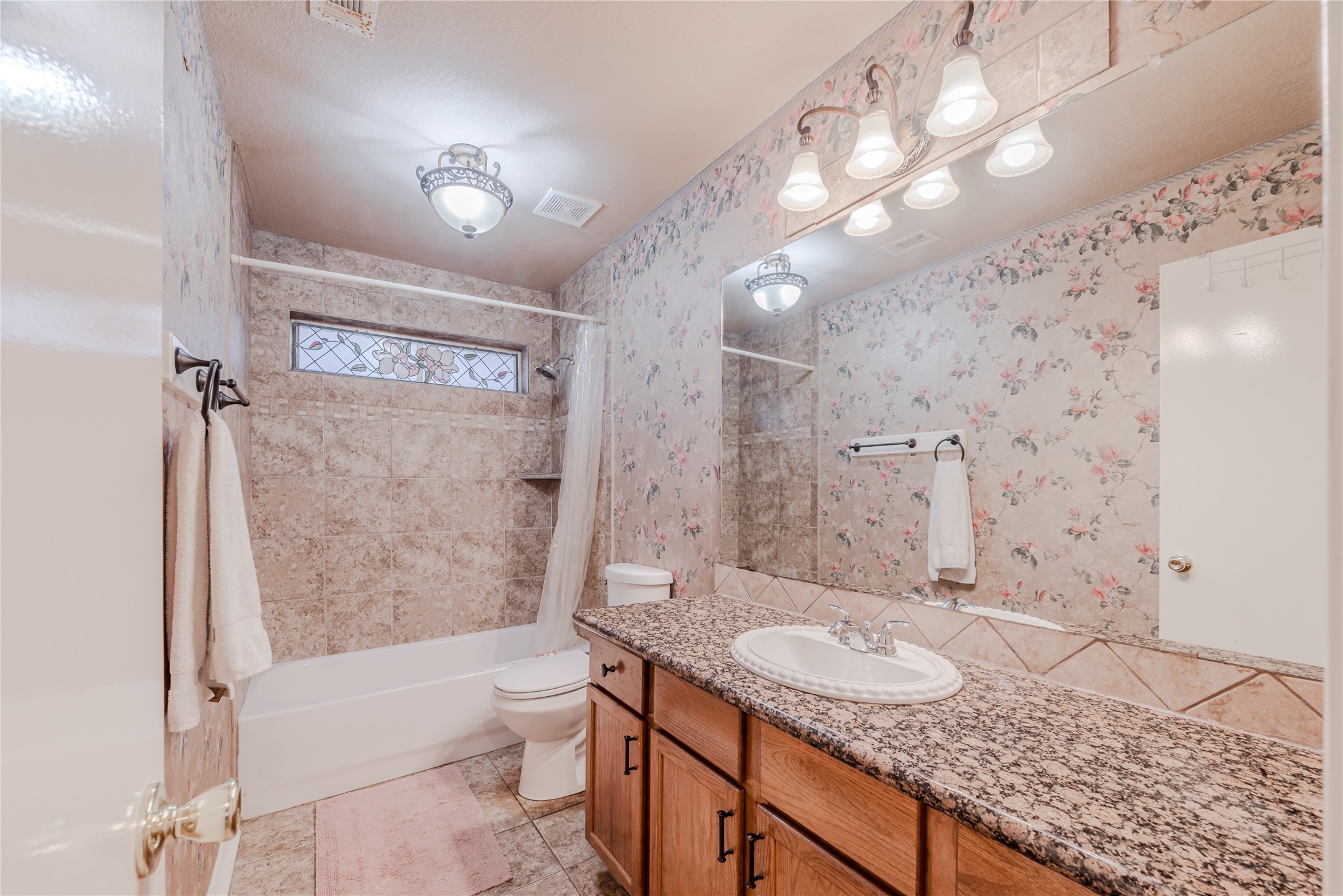7714 Broken Arrow Street Baytown, TX 77521 - Photo 30 of 41 a bathroom with a granite countertop sink a toilet and shower