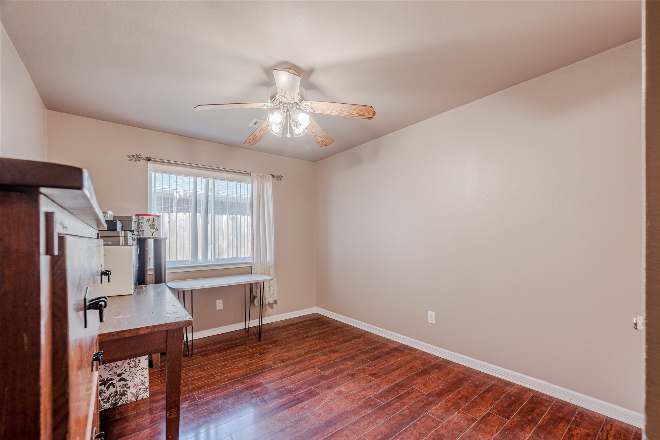 7714 Broken Arrow Street Baytown, TX 77521 - Photo 31 of 41 a view of an empty room with wooden floor and a window