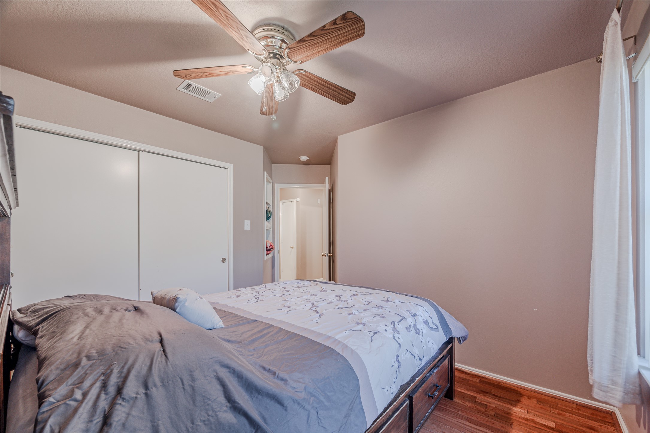 7714 Broken Arrow Street Baytown, TX 77521 - Photo 34 of 41 a bedroom with a bed and a chandelier