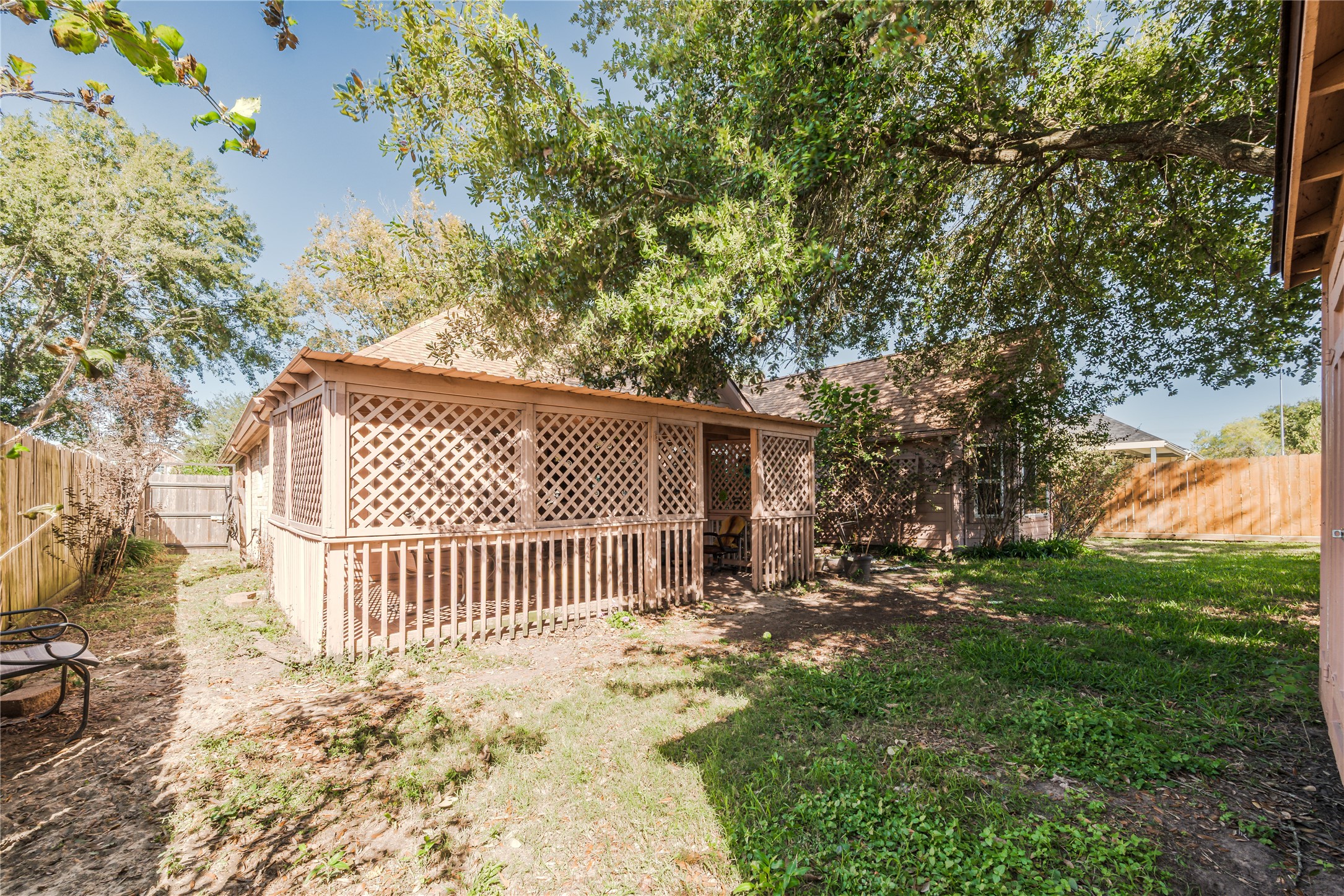 7714 Broken Arrow Street Baytown, TX 77521 - Photo 40 of 41 a view of a yard with wooden fence and a bench