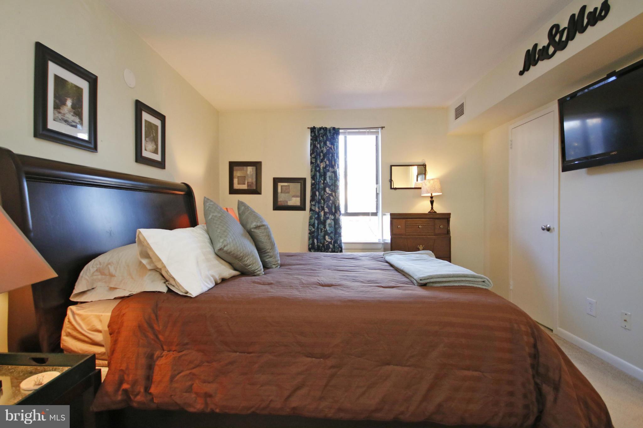 2210 Castle Rock Square, Unit 1B Reston, VA 20191 - Photo 12 of 26 a bedroom with a bed and a flat screen tv