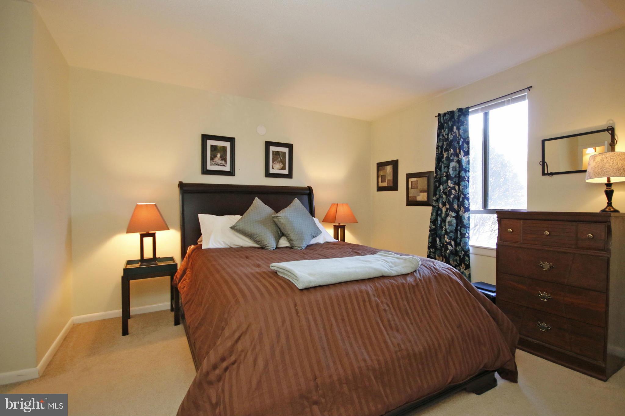 2210 Castle Rock Square, Unit 1B Reston, VA 20191 - Photo 13 of 26 a bedroom with a bed and a dresser