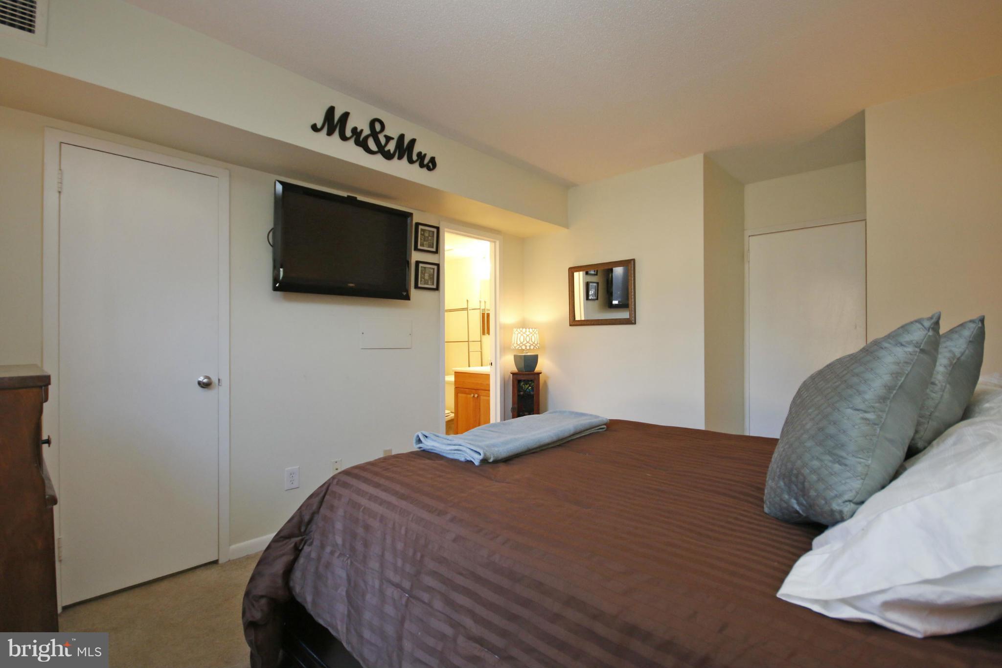 2210 Castle Rock Square, Unit 1B Reston, VA 20191 - Photo 15 of 26 a bedroom with a bed a flat screen tv and dresser