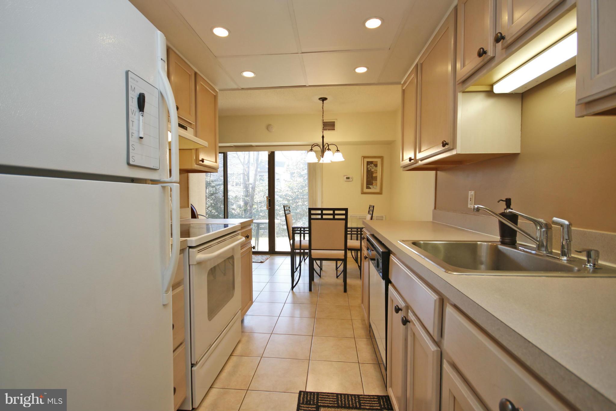2210 Castle Rock Square, Unit 1B Reston, VA 20191 - Photo 6 of 26 a kitchen with stainless steel appliances granite countertop a sink a stove and a refrigerator