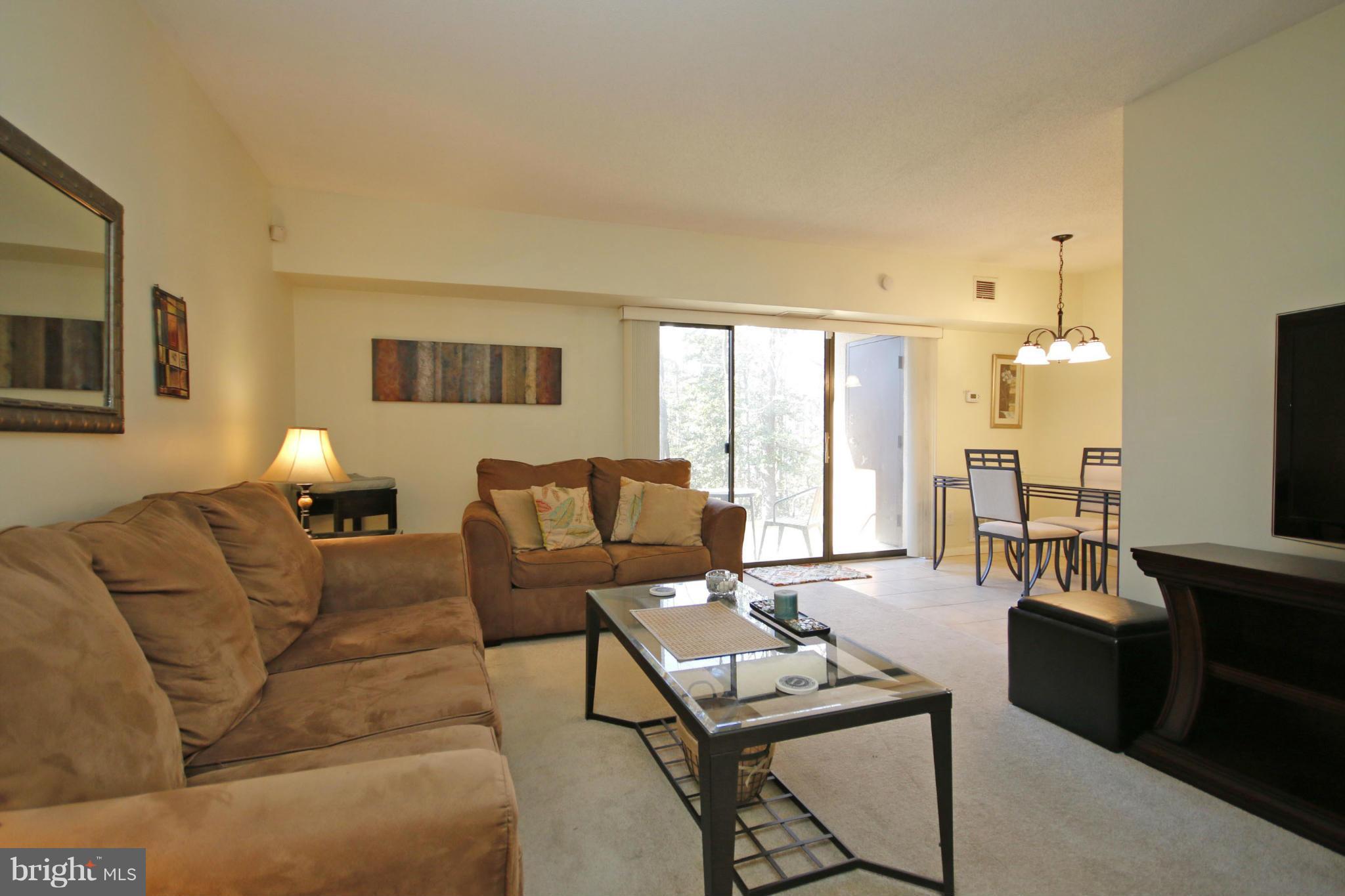 2210 Castle Rock Square, Unit 1B Reston, VA 20191 - Photo 9 of 26 a living room with furniture and a flat screen tv