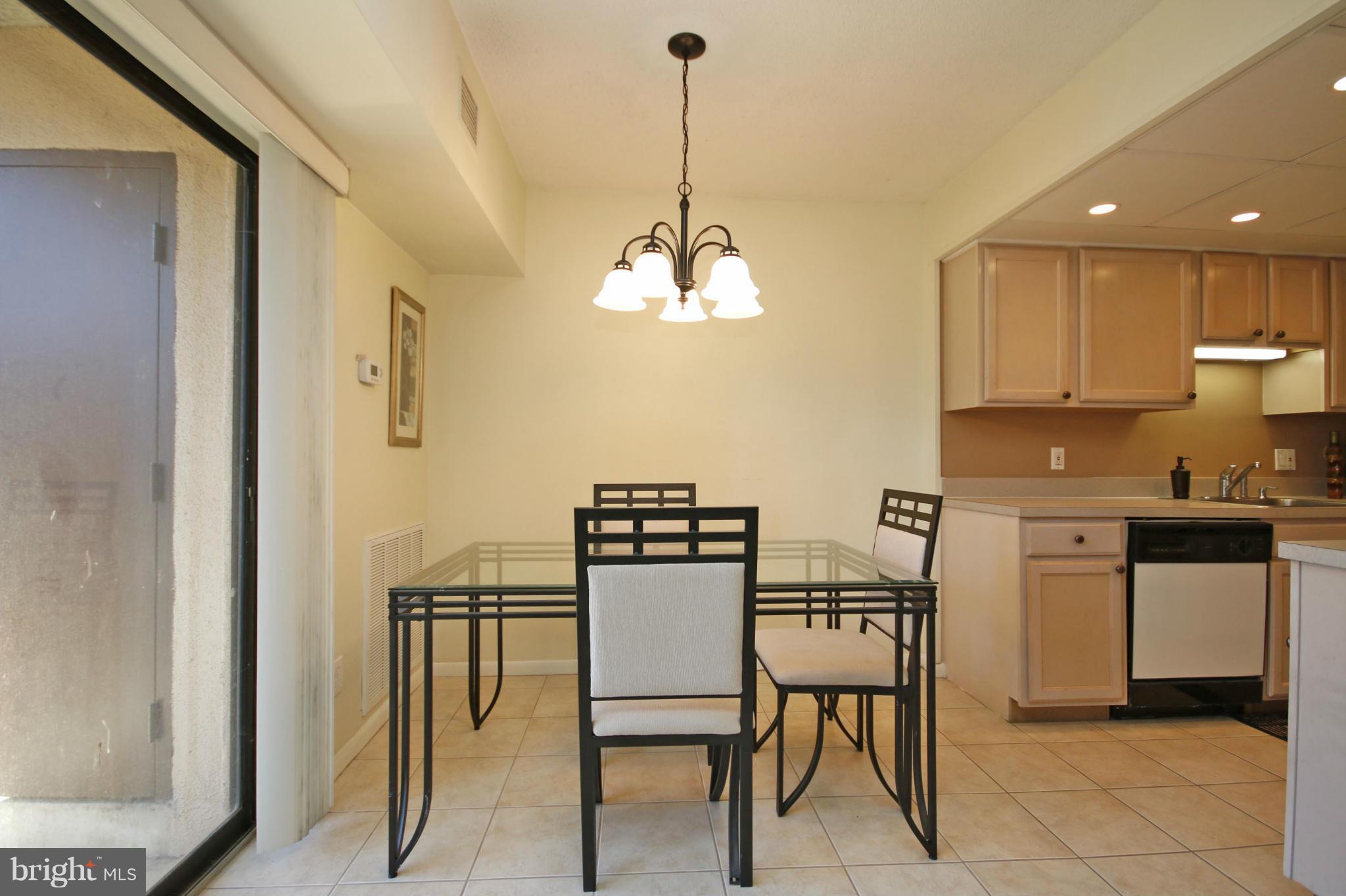 2210 Castle Rock Square, Unit 1B Reston, VA 20191 - Photo 10 of 26 a kitchen with stainless steel appliances kitchen island granite countertop a table and chairs in it