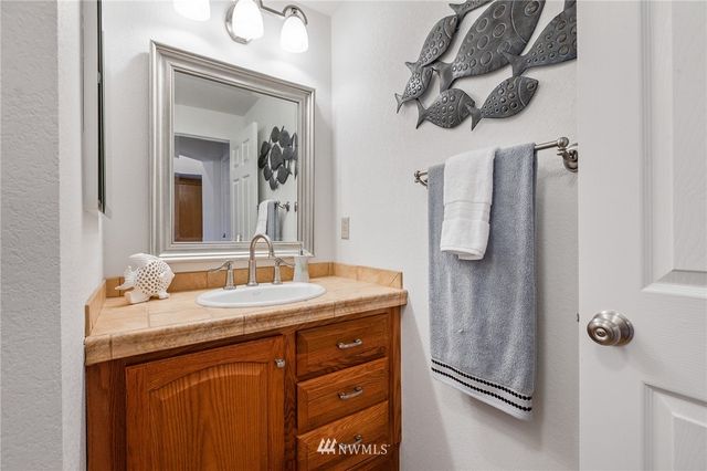 a bathroom with a granite countertop sink vanity and mirror
