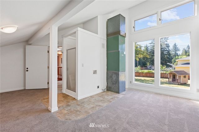 an empty room with a fireplace and large window