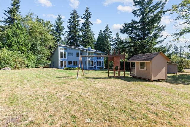 a view of a house with backyard and trees