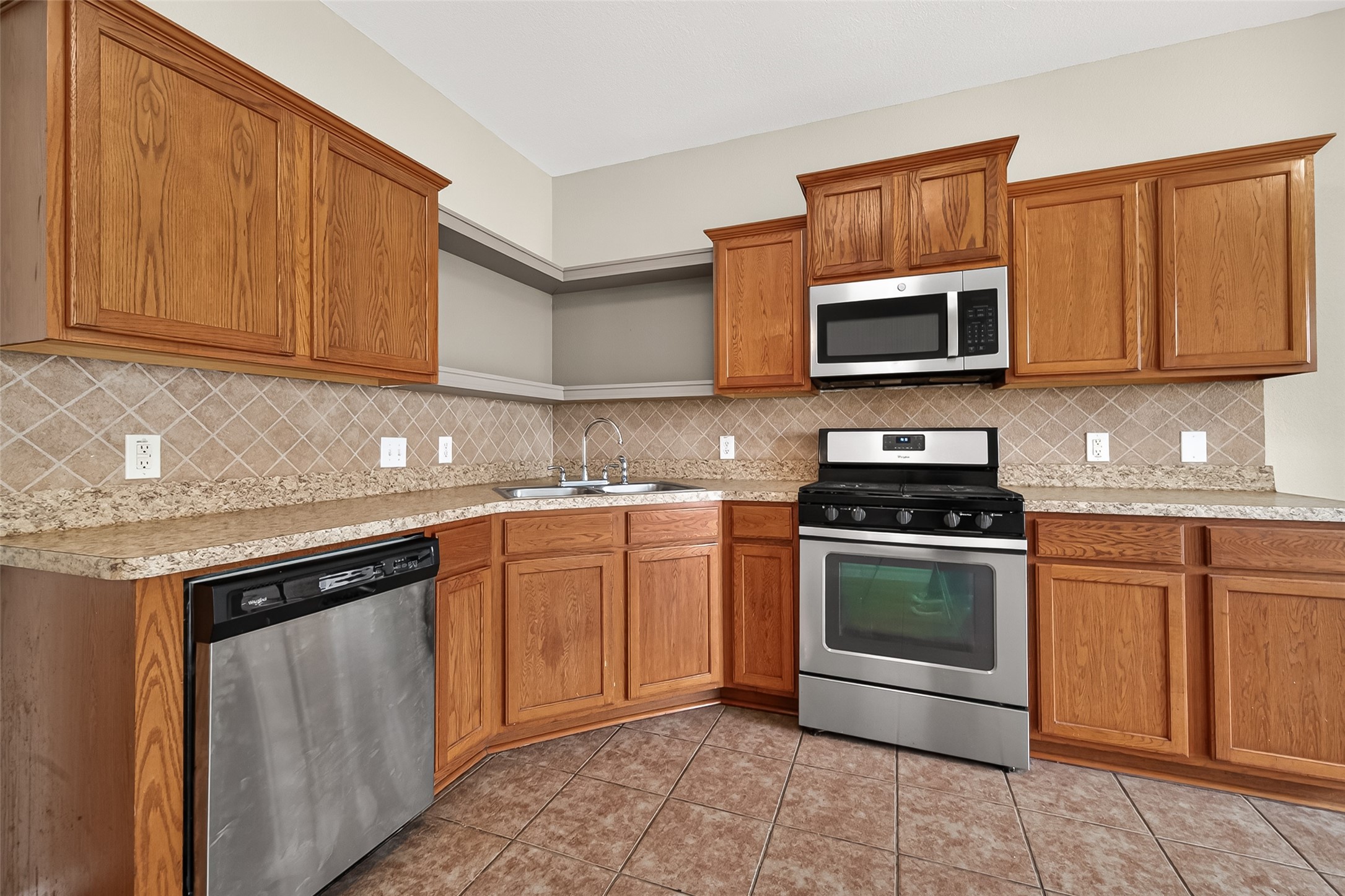 21327 Bella Flora Court Spring, TX 77379 - Photo 15 of 50 a kitchen with stainless steel appliances granite countertop a sink stove and microwave