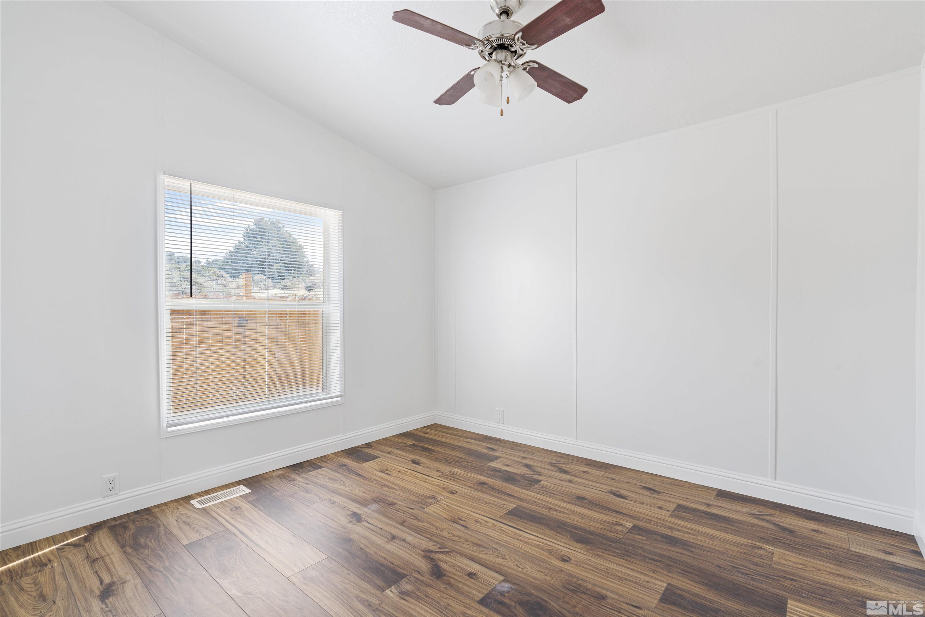 16000 Perlite Drive Reno, NV 89521 - Photo 16 of 29 an empty room with wooden floor fan and windows