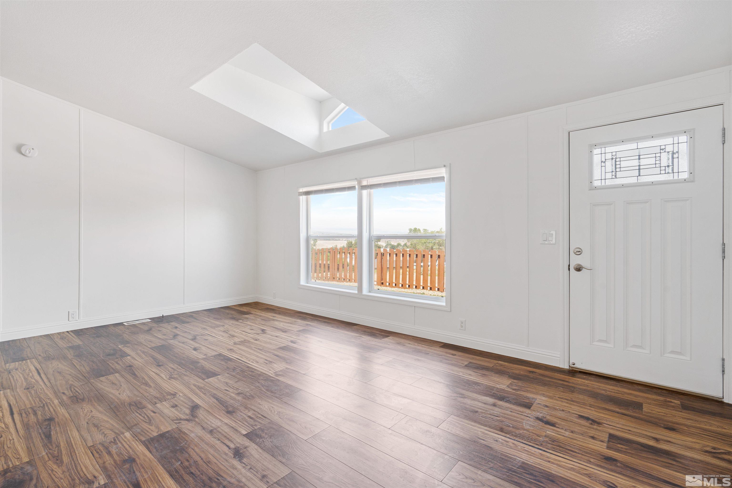 16000 Perlite Drive Reno, NV 89521 - Photo 3 of 29 an empty room with wooden floor and windows