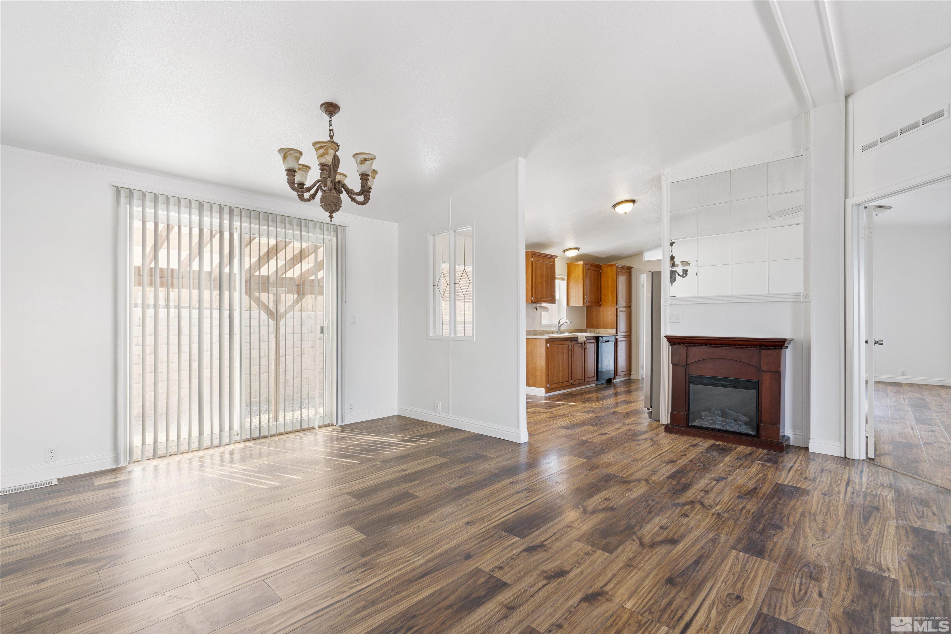 16000 Perlite Drive Reno, NV 89521 - Photo 4 of 29 an empty room with wooden floor fireplace and windows