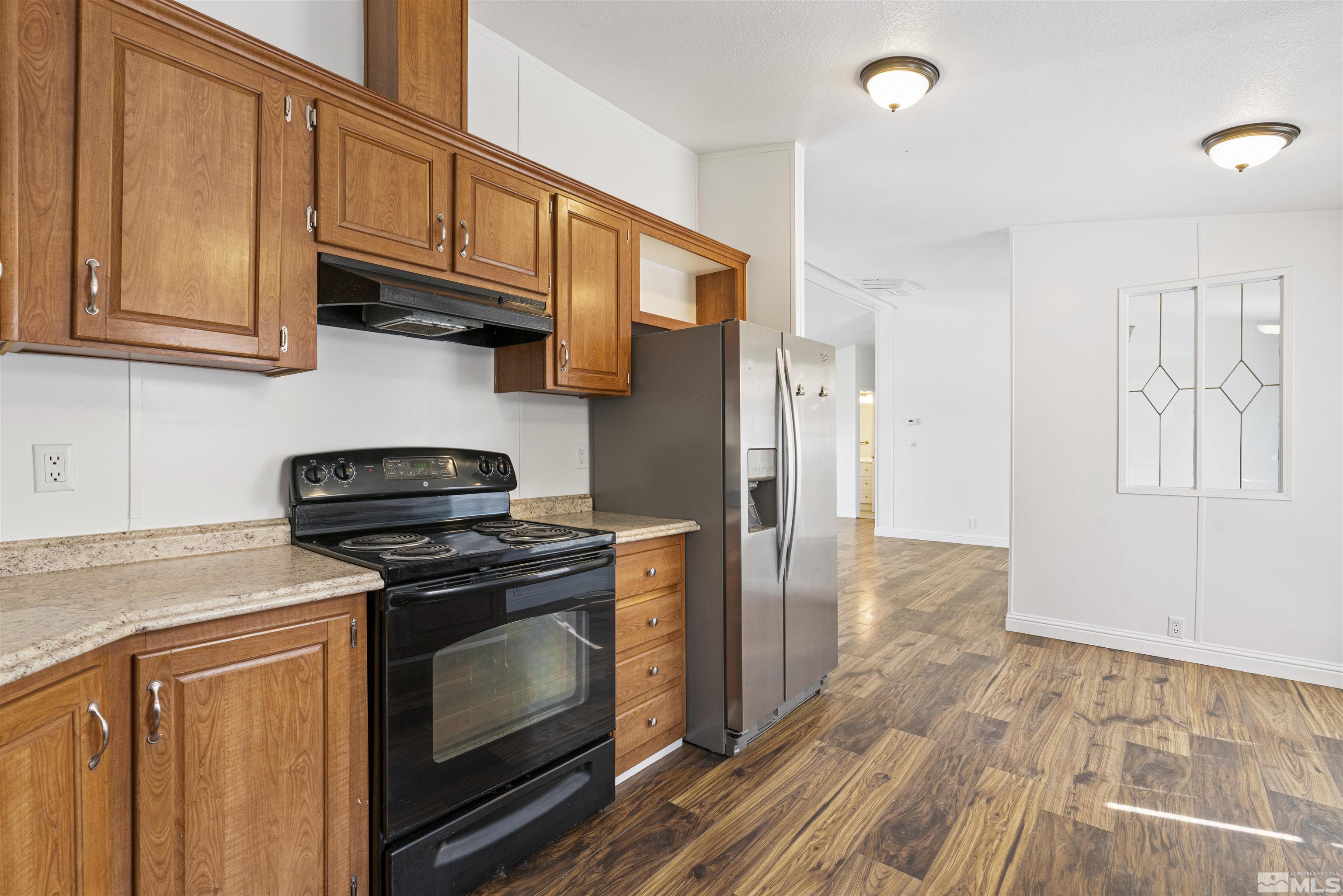 16000 Perlite Drive Reno, NV 89521 - Photo 8 of 29 a kitchen with stainless steel appliances granite countertop a stove a sink and a refrigerator