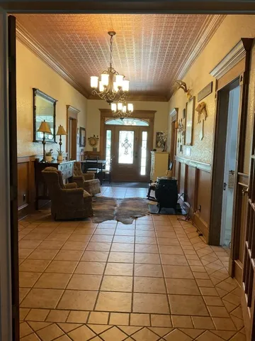 a bed sitting in a bedroom next to a window and a chair