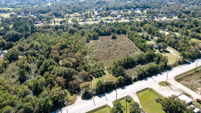 an aerial view of a house with a yard and lake view