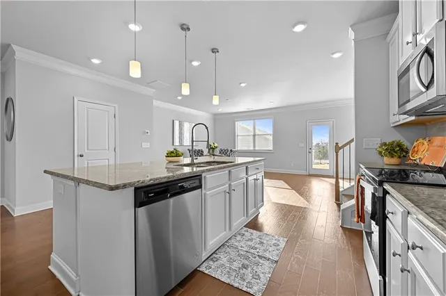 a kitchen with stainless steel appliances granite countertop a sink and stove