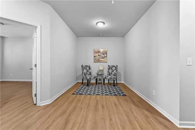 a view of a room with wooden floor and white walls