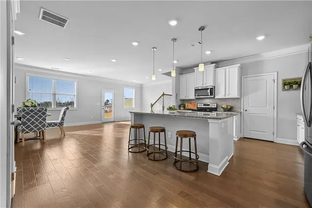 a open kitchen with white cabinets and stainless steel appliances