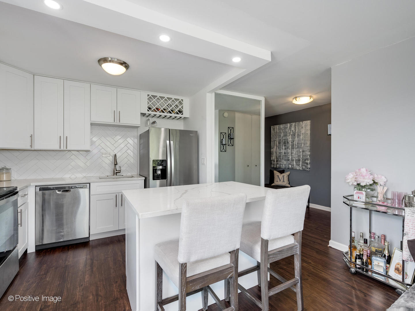 1850 North Clark Street, Unit 407 Chicago, IL 60614 - Photo 9 of 23 a large kitchen with kitchen island a dining table chairs and white cabinets
