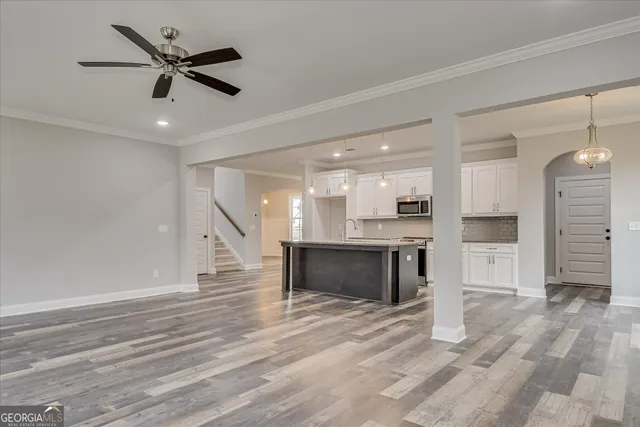 a kitchen with kitchen island granite countertop a sink a stove and cabinets