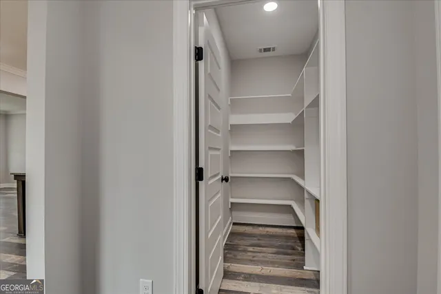 a view of a closet with wooden floor