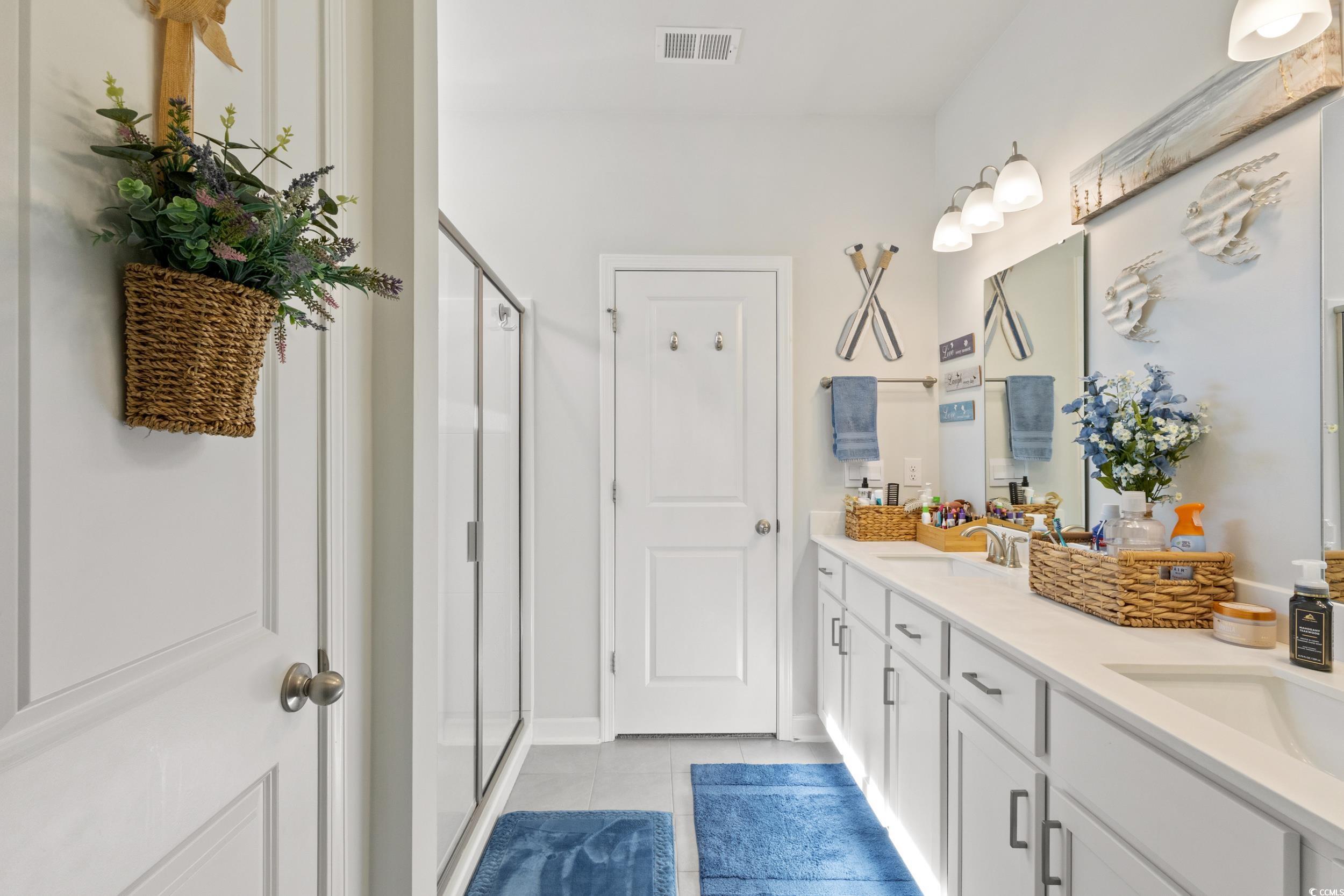 6037 Mcclain Court Little River, SC 29566 - Photo 25 of 39 Bathroom featuring double vanity, light tile patterned floors, and a shower stall