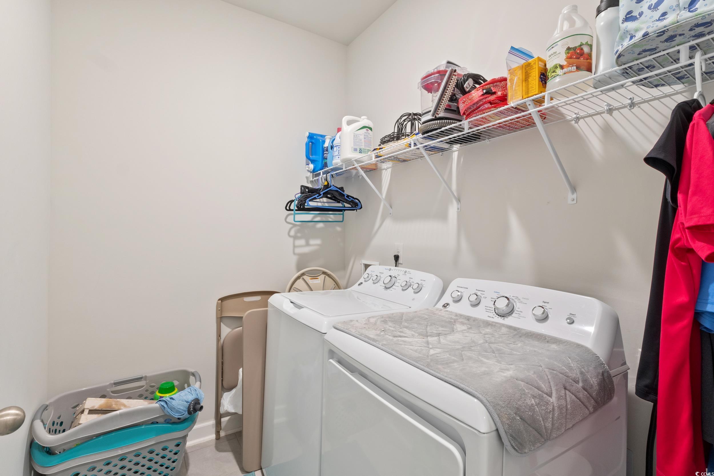 6037 Mcclain Court Little River, SC 29566 - Photo 26 of 39 Laundry area with washing machine and dryer and baseboards
