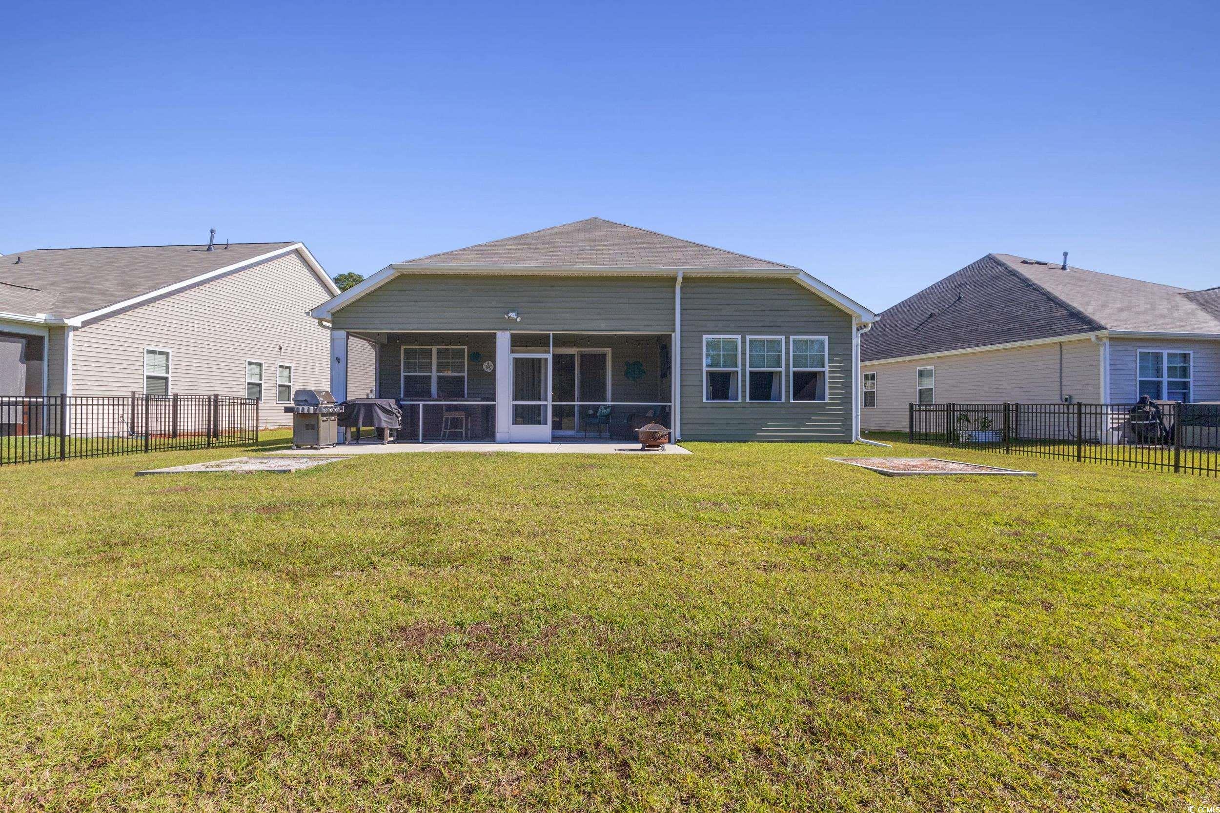 6037 Mcclain Court Little River, SC 29566 - Photo 27 of 39 Back of house featuring a sunroom and a fenced backyard