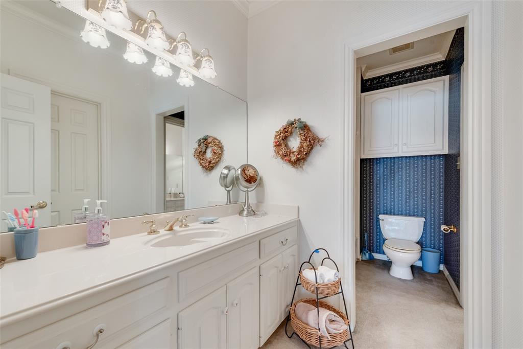 2251 English Road Rockwall, TX 75032 - Photo 22 of 36 a bathroom with a sink a toilet and a mirror