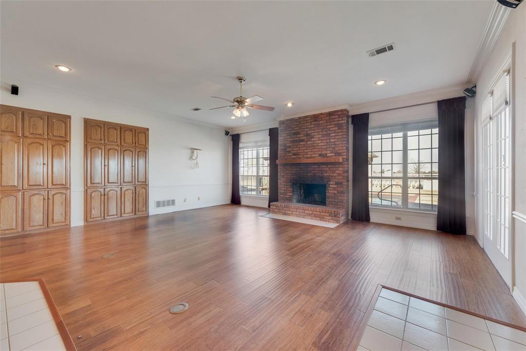 2251 English Road Rockwall, TX 75032 - Photo 10 of 36 an empty room with wooden floor fireplace and windows