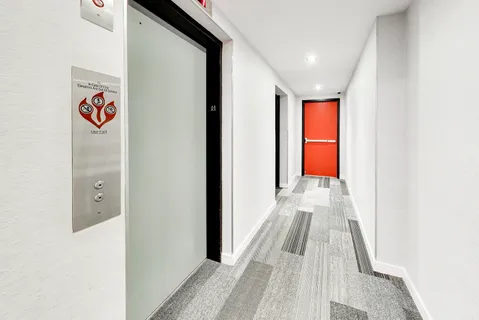 a view of a hallway with wooden floor and windows