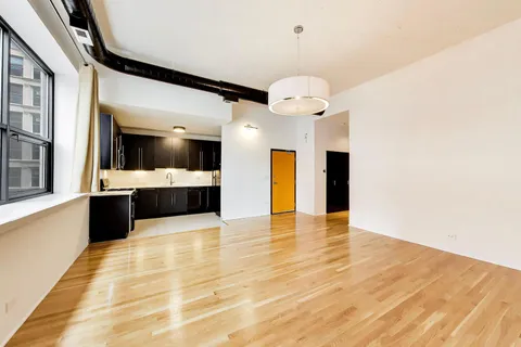 a view of an empty room and kitchen view