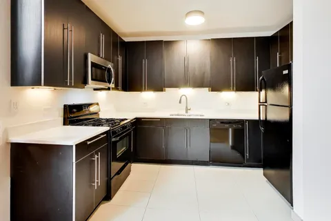 a kitchen with stainless steel appliances kitchen island granite countertop a sink stove and refrigerator