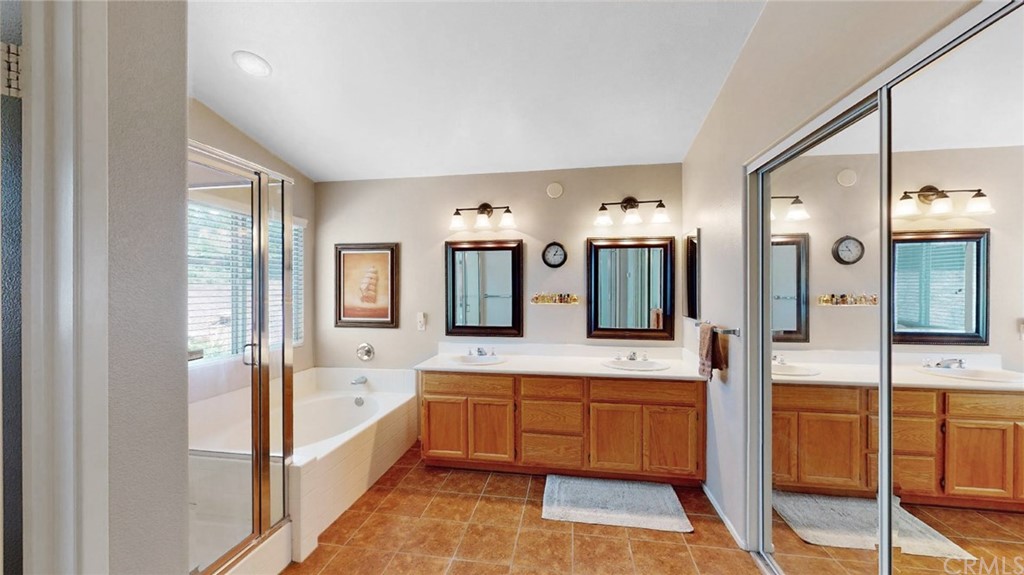3685 Sedlock Drive Corona, CA 92881 - Photo 22 of 34 a bathroom with a tub a double vanity sink and mirror