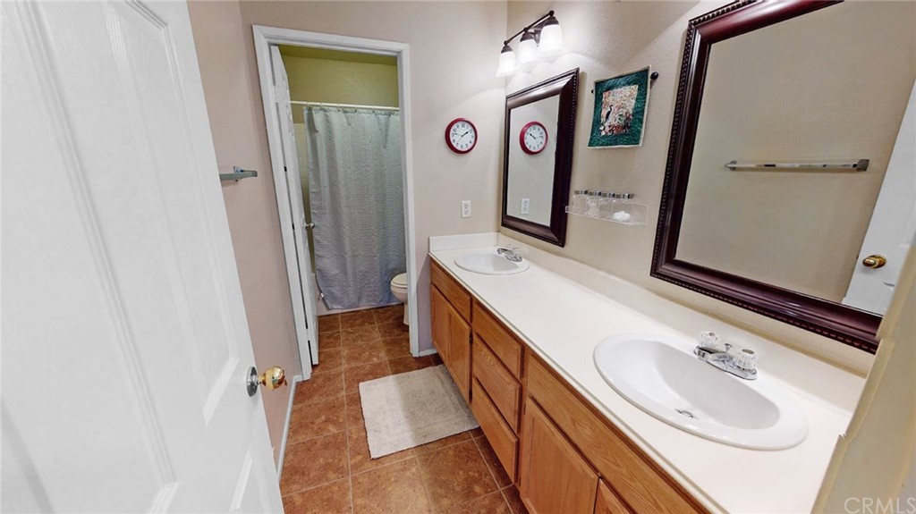 3685 Sedlock Drive Corona, CA 92881 - Photo 25 of 34 a bathroom with a sink a mirror and a shower
