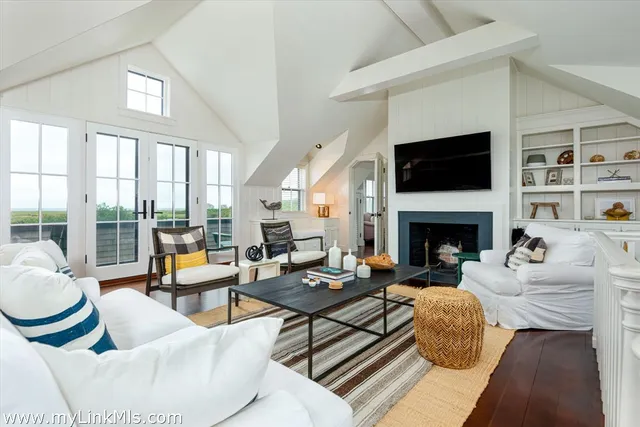 a living room with furniture a flat screen tv and a fireplace