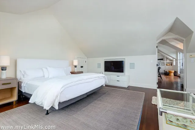 a bedroom with a bed and flat screen tv