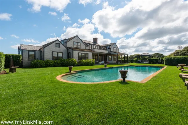 a view of a house with a swimming pool and a yard