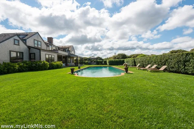a view of a house with a big yard and a fountain