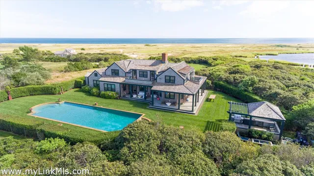 an aerial view of a house with a garden and lake view