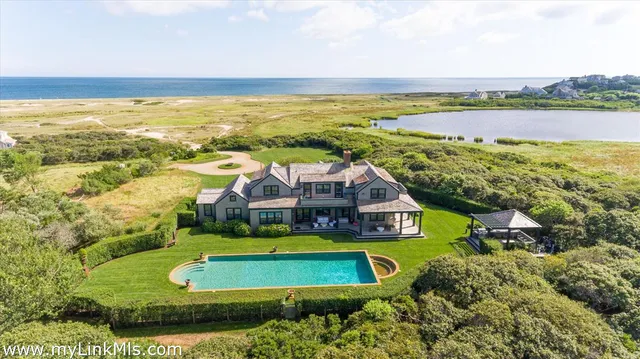 an aerial view of a house with a swimming pool outdoor seating and yard
